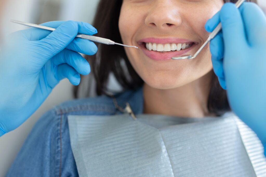 imagen de una paciente en el dentista siendo examinada para una limpieza dental