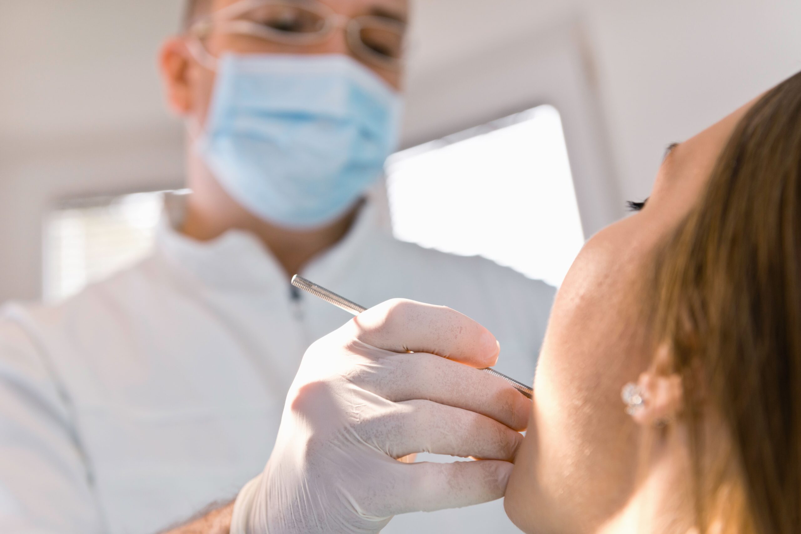 imagen de un doctor revisando la boca de un paciente en la clincia dental tecnolaser en barbate